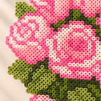 Close-up of pink rose and green leaf details in the fuse bead bouquet artwork.